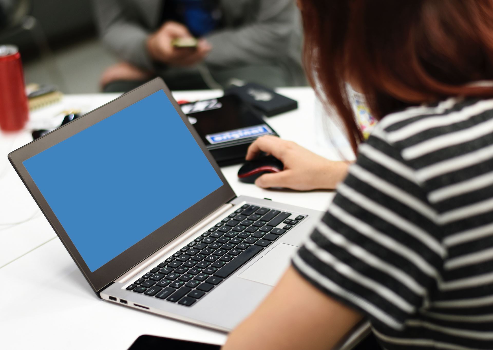 a woman sitting at a table using a laptop computer